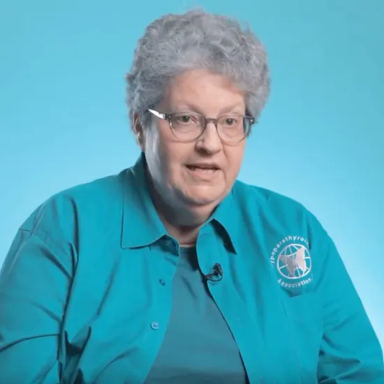 Headshot of Deb speaking over blue background in video